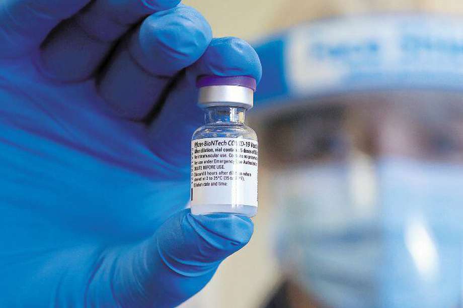 Un trabajador del NHS (Servicio Nacional de Salud) sostiene un vial de la vacuna Pfizer-Biontech en Inglaterra / AFP, Chris Jackson.