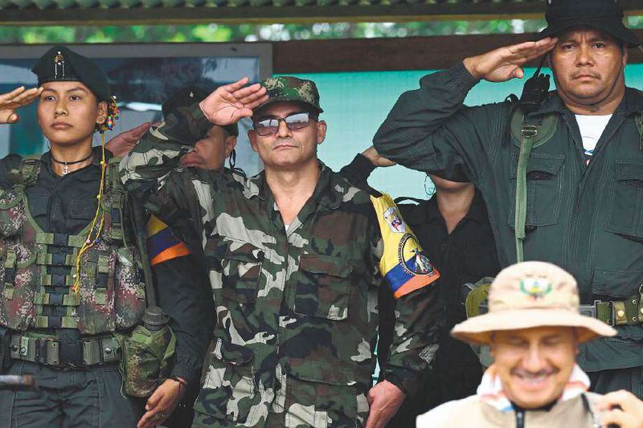 FARC EP dissidence top commander, aka Ivan Mordisco (C), gives a military salute next to commander Calarca (R) during a meeting with local communities in San Vicente del Caguan, Caqueta department, Colombia, on April 16, 2023. An armed dissident group of Colombia's disbanded FARC guerrillas said Sunday it was "ready" to start peace talks with the government from May 16. "We are announcing to the world that our delegates to the dialogue table with the Colombian government... are ready for May 16," the EMC dissident grouping, which rejected a 2016 peace deal that disarmed the FARC, said through a spokesperson. (Photo by JOAQUIN SARMIENTO / AFP)
