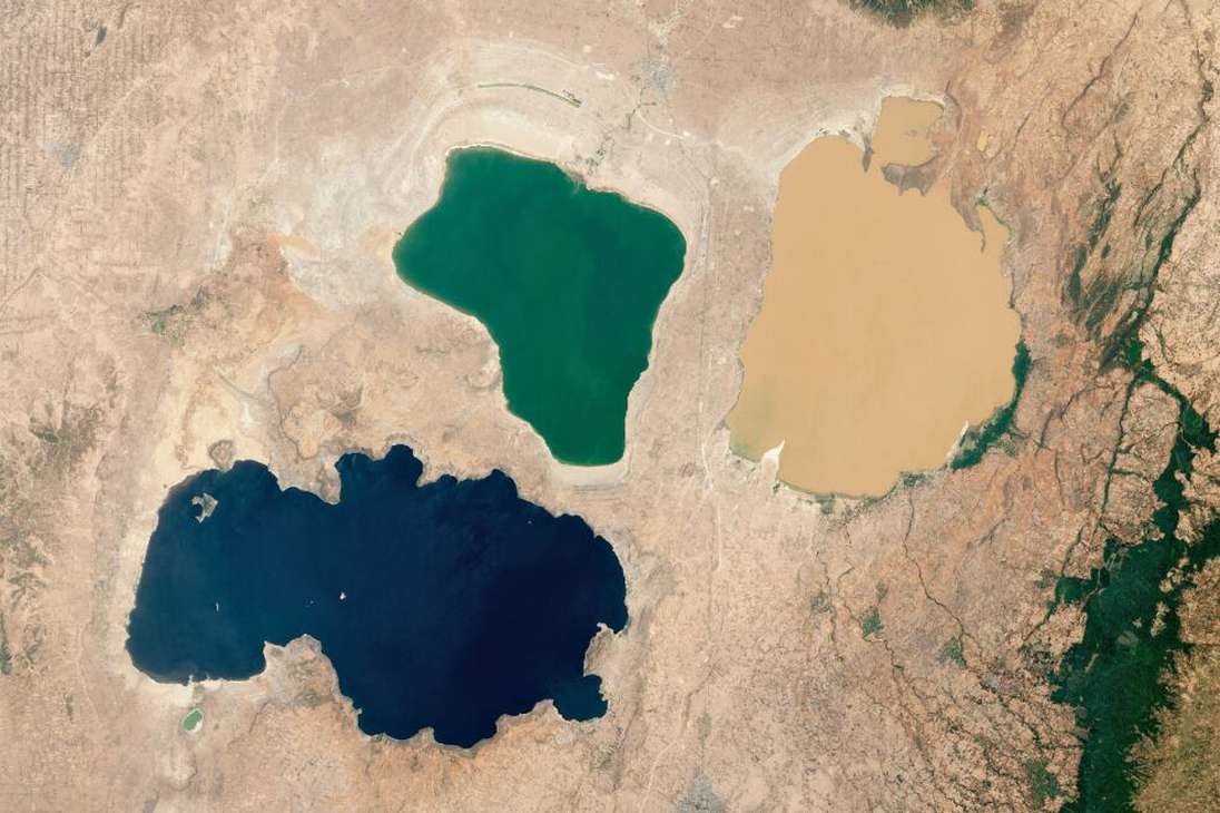 Una sorprendente imagen de un trío de lagos multicolores en el Gran Valle del Rift de Etiopía: Lago Shala (izquierda), Lago Abijatta (centro) y Lago Langano (derecha). 
El color azul oscuro del lago Shala se debe a la profundidad de sus aguas, que alcanzan los 266 metros. El lago Abijatta, que sólo tiene una profundidad máxima de 14 m, es verde gracias a una floración de algas fotosintéticas. El lago Langano, por su parte, adquiere su color amarillo gracias a los ríos que transportan hasta allí sedimentos de las montañas cercanas.