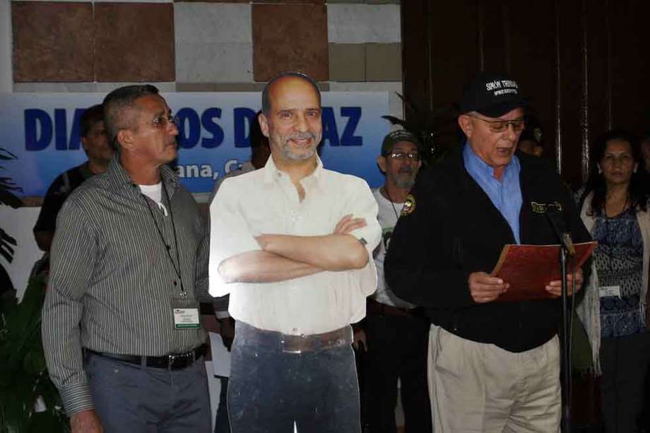 HAB302 LA HABANA (CUBA) 23/11/12.- El guerrillero Rodrigo Granda (d), alias "Ricardo Téllez", lee una declaración junto a una una silueta de cartón a tamaño natural de Simón Trinidad (c) hoy, viernes 23 de noviembre de 2012, a la entrada del Palacio de Convenciones, sede del diálogo entre el Gobierno colombiano y la guerrilla en La Habana (Cuba). Las FARC insistieron en pedir al presidente de EE.UU, Barack Obama, que, en el "uso de su facultad para indultar", permita que el guerrillero Simón Trinidad, preso en ese país norteamericano, pueda estar presente en los diálogos de paz en la isla. EFE/Str

