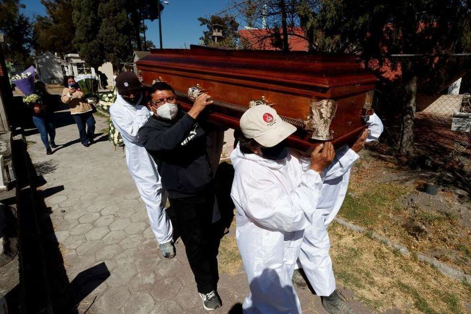 Familiares asisten al entierro de un fallecido por Covid-19 en el Panteón de Tlahuac, en Ciudad de México (México).