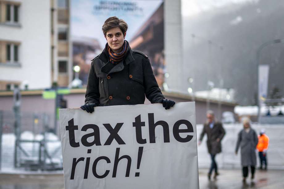 La austriaca Marlene Engelhorn, que heredó de su familia la propiedad del gigante químico alemán BASF, posa con un cartel que dice "¡Graven a los ricos!".