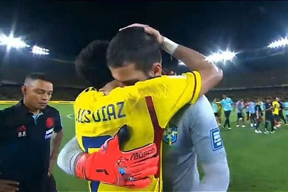 Luis Díaz, de Colombia, y Allison Becker, de Brasil, compañeros de Liverpool de Inglaterra comparten un abrazo tras su choque en Eliminatorias.