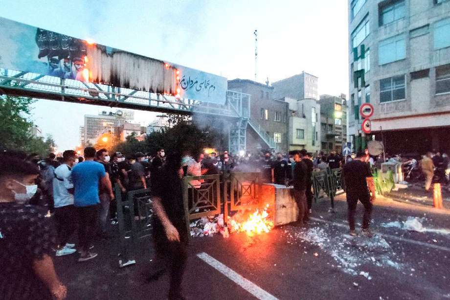 Una imagen obtenida por AFP el 21 de septiembre de 2022 muestra a manifestantes iraníes quemando un contenedor de basura en la capital, Teherán, durante una protesta tras la muerte de Mahsa Amini.