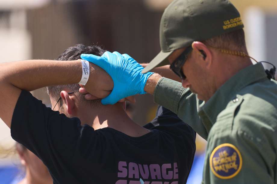 Imagen de referencia. Un agente de la Patrulla Fronteriza de Estados Unidos procesa a migrantes que habían estado acampando entre las dos vallas fronterizas en la frontera sur de Estados Unidos con México en San Diego, California.