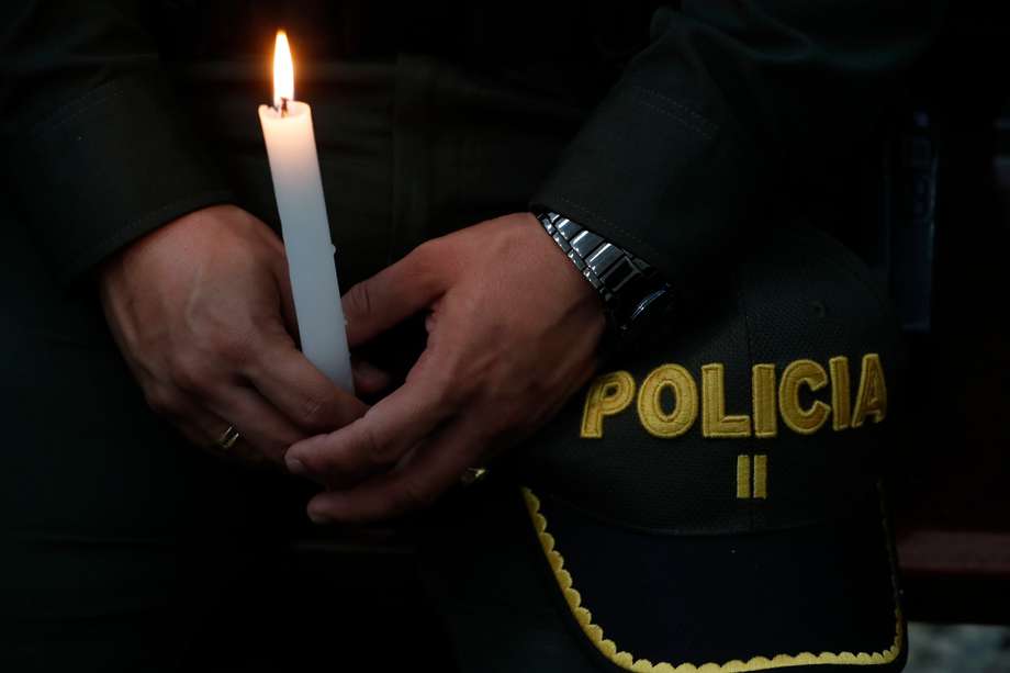 Un policía sostiene una vela durante una ceremonia religiosa en honor a sus compañeros asesinados recientemente en el país por el Clan del Golfo, en Cali. EFE/ Ernesto Guzmán Jr
