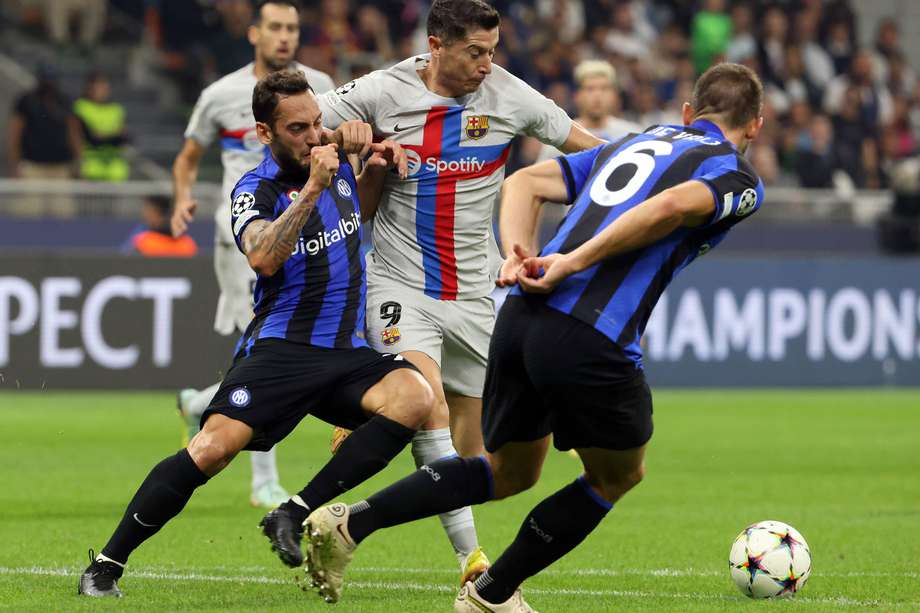 Hakan Calhanoglu (izquierda) disputa el balón con Robert Lewandowski, durante el partido de la tercera fecha de la fase de grupos de Champions entre Inter y Barcelona..