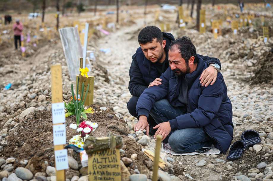 Familiares de una de las víctimas de los terremotos en Turquía visitan su tumba.