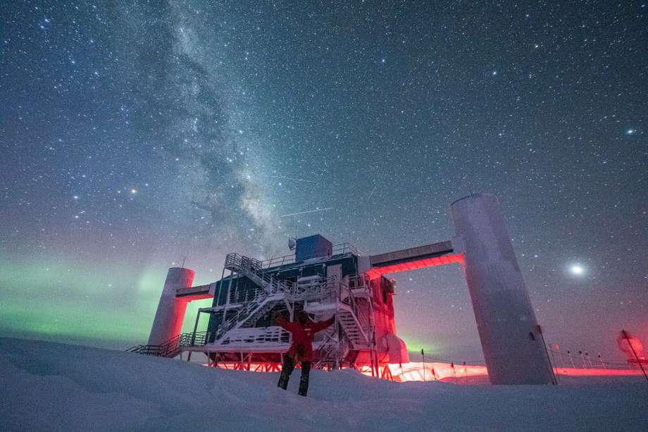 El telescopio IceCube, ubicado en el Polo Sur, con auroras y la Vía Láctea de fondo.