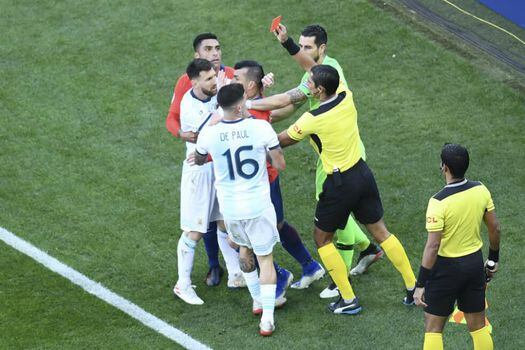 Momento en el que Mario Díaz expulsa a Lionel Messi y Gary Medel. / AFP