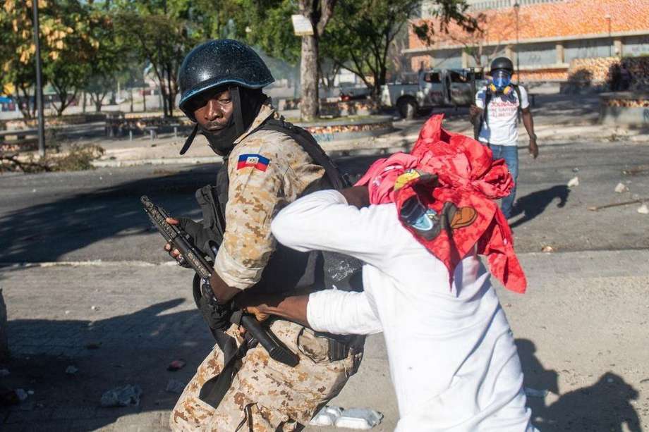 Un policía enfrenta a un manifestante cerca del Palacio Nacional en Puerto Príncipe (Haití).