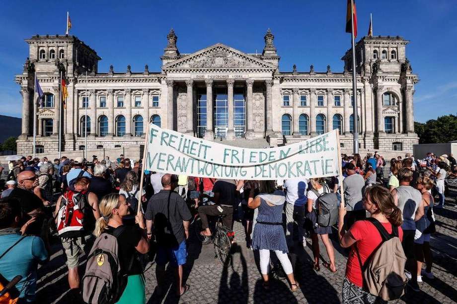Docenas de manifestantes se reúnen frente al Reichstag durante una protesta contra las regulaciones de la pandemia de coronavirus en Berlín, Alemania.