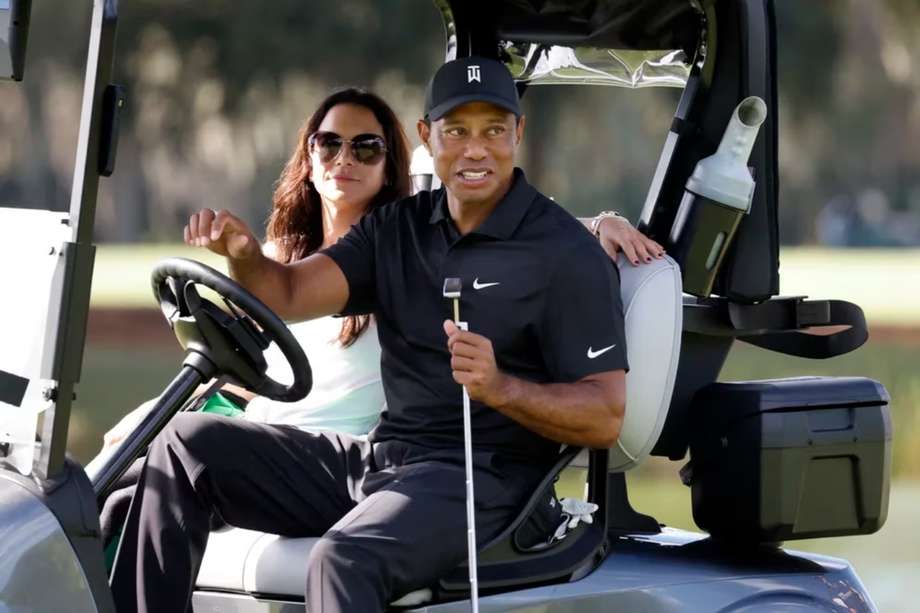 Erica Herman junto a Tiger Woods un campo de golf de Florida.