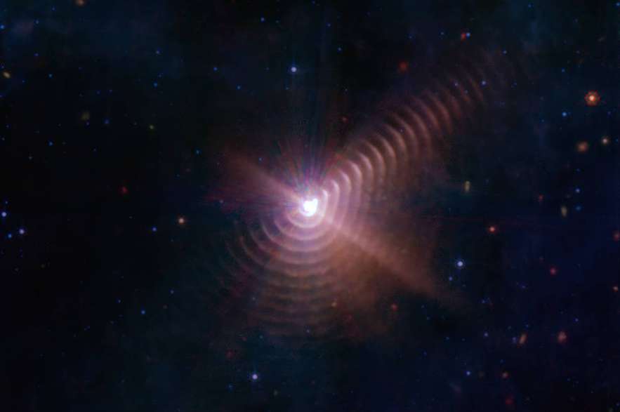 Las dos estrellas en Wolf-Rayet 140 producen capas de polvo cada ocho años que parecen anillos, como se ve en esta imagen del Telescopio Espacial James Webb de la NASA.