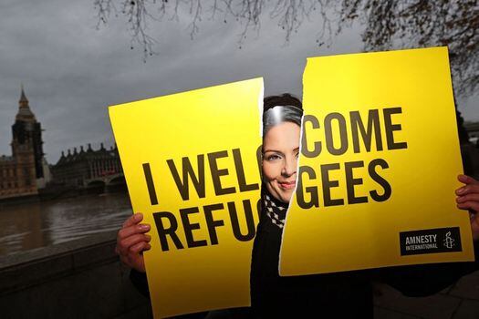 Un activista de Amnistía Internacional con una máscara que representa a la ministra del Interior de Gran Bretaña, Priti Patel, se manifiesta delante del proyecto de ley de Nacionalidad y Fronteras del Gobierno, frente a las Casas del Parlamento en Londres.