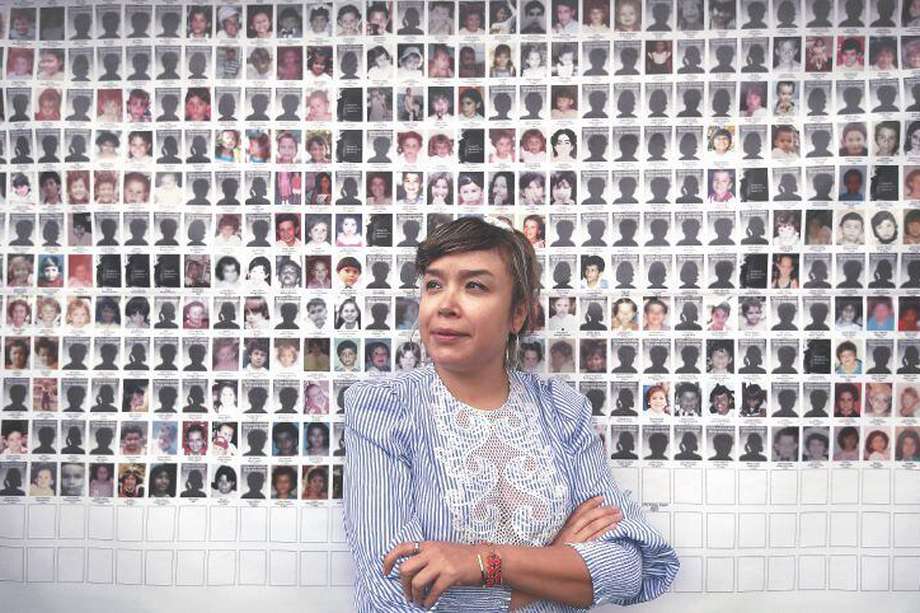 La artista Jenifer de la Rosa y, al fondo, los más de 514 casos de niños y niñas perdidos de Armero