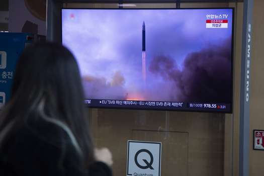 Una mujer sigue el lanzamiento de un misil de corto alcance norcoreano en una televisión instalada en una estación de Seúl, Corea del Sur. 