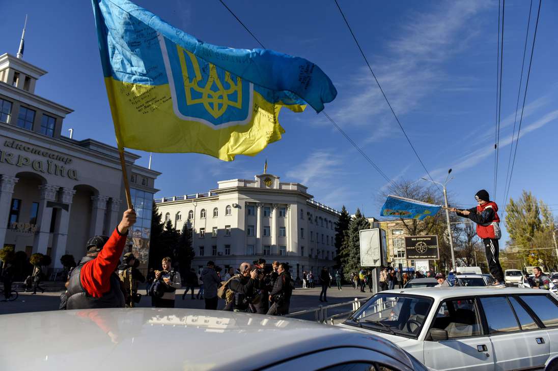 Kherson (Ukraine), 14/11/2022.- People wave Ukrainian flags during a patriotic rally after Presidnet Zelesnky's visit to the recaptured city of Kherson, Ukraine, 14 November 2022. Ukrainian troops entered Kherson on 11 November after Russian troops had withdrawn from the city. Kherson was captured in the early stage of the conflict, shortly after Russian troops had entered Ukraine in February 2022. (Rusia, Ucrania) EFE/EPA/OLEG PETRASYUK