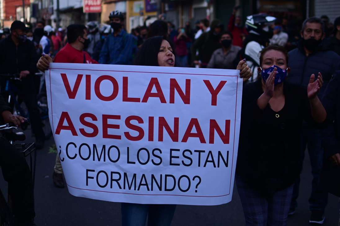 Una mujer sostiene un cartel en el que se lee: viola y asesinan ¿cómo los están formando?