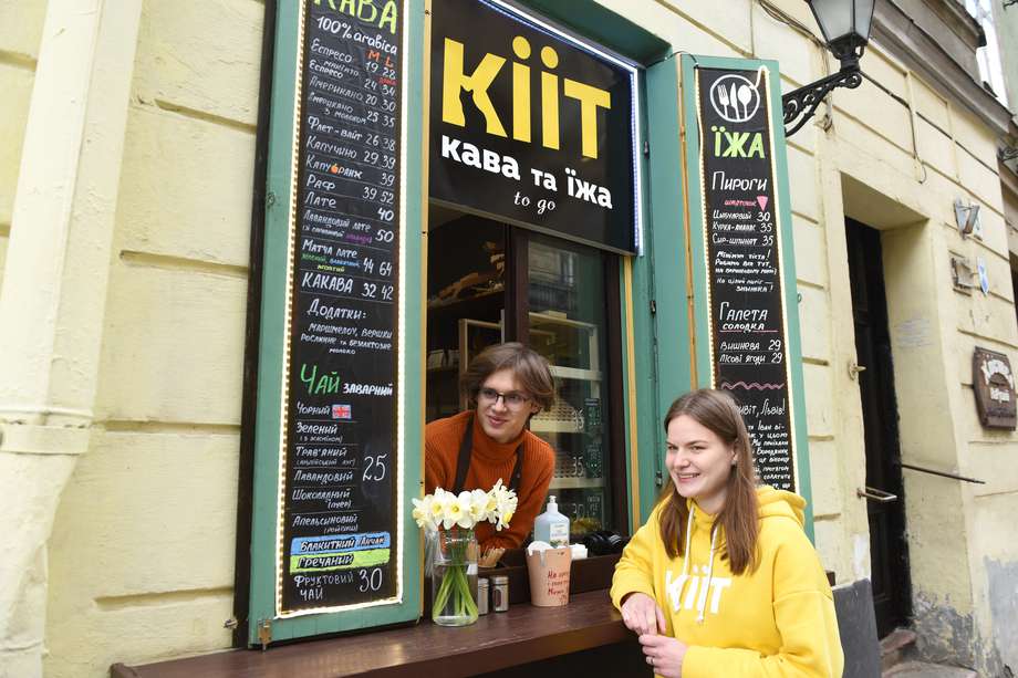Ivan Denchenko (izquierda), de 19 años, y Daryna Mazur (derecha), de 21, que trabajan en el café Kiit, posan para una foto en la ciudad de Lviv, en el oeste de Ucrania, el 12 de abril de 2022, en medio de la invasión militar rusa lanzada contra Ucrania. Después de huir de la capital, Demchenko y su amigo Serhii Stoian comenzaron a vender café desde una ventana de la planta baja en Lviv.