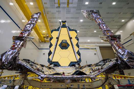 El telescopio espacial James Webb ensamblado con parasol y estructuras de paletas unificadas (UPS) que se pliegan alrededor del telescopio para su lanzamiento, se ven parcialmente desplegadas en una configuración abierta para permitir la instalación del telescopio. / NASA