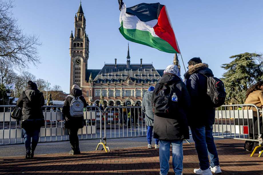 Varias personas frente al Palacio de la Paz antes de que la Corte Internacional de Justicia (CIJ) se pronuncie sobre una petición de Sudáfrica de medidas de emergencia para Gaza, en La Haya, Países Bajos, 26 de enero de 2024.