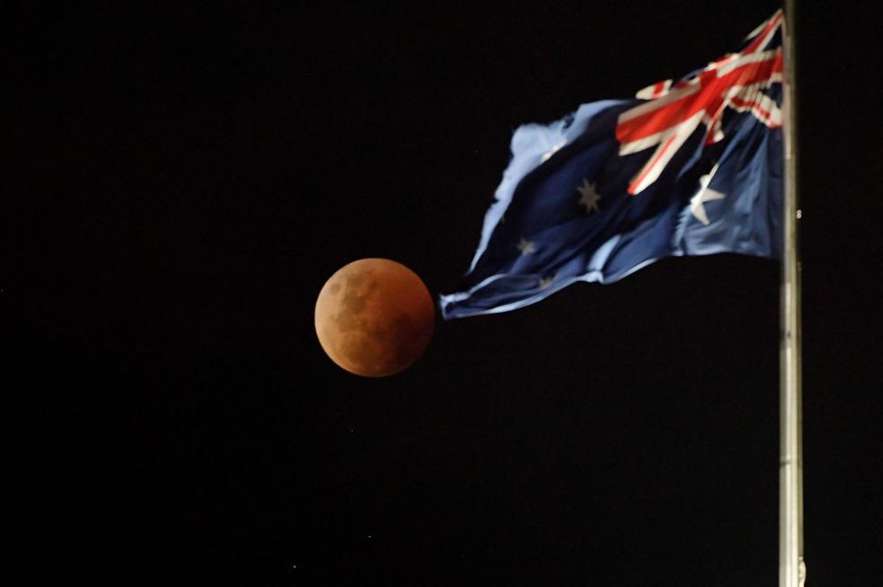 La luna llena de sangre se eleva sobre el Parlamento australiano en Canberra.