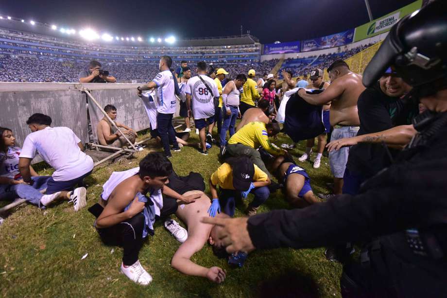 Fanáticos auxilian a personas durante una estampida en el Estadio Cuscatláán previo a un partido de la Liga Mayor en San Salvador (El Salvador). 