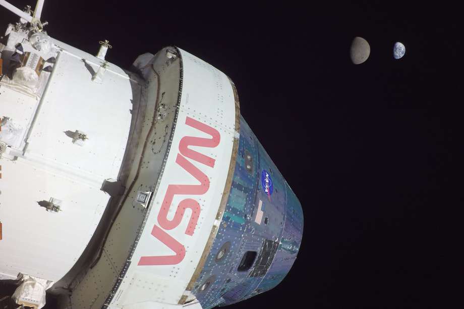 Fotografía que muestra a la cápsula Orión de la misión no tripulada Artemis I al momento de alcanzar una distancia de 432.210 kilómetros (268.563 millas). Al fondo se ve la Luna y la Tierra. 