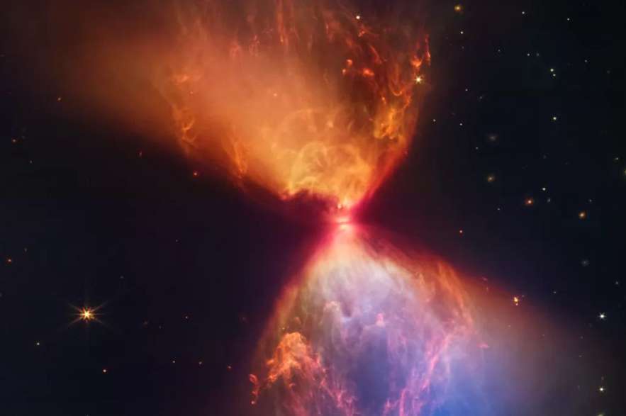 Este "reloj de arena celestial" esconde en su centro a una estrella recién formada, conocida como protoestrella L1527, a unos 430 años luz de la Tierra.
Esta escena no había sido captada por otros telescopios espaciales, pues estaba tapada por una densa y oscura nube de gas y polvo conocida como L1527. La escena sólo es visible en luz infrarroja.
