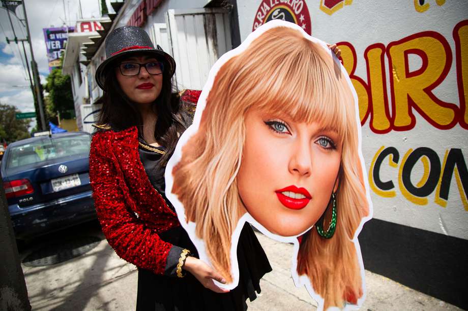 Una fan de la superestrella estadounidense Taylor Swift sostiene un cartel con la imagen de la cantante antes de su presentación en el Foro Sol de la Ciudad de México el 24 de agosto de 2023.