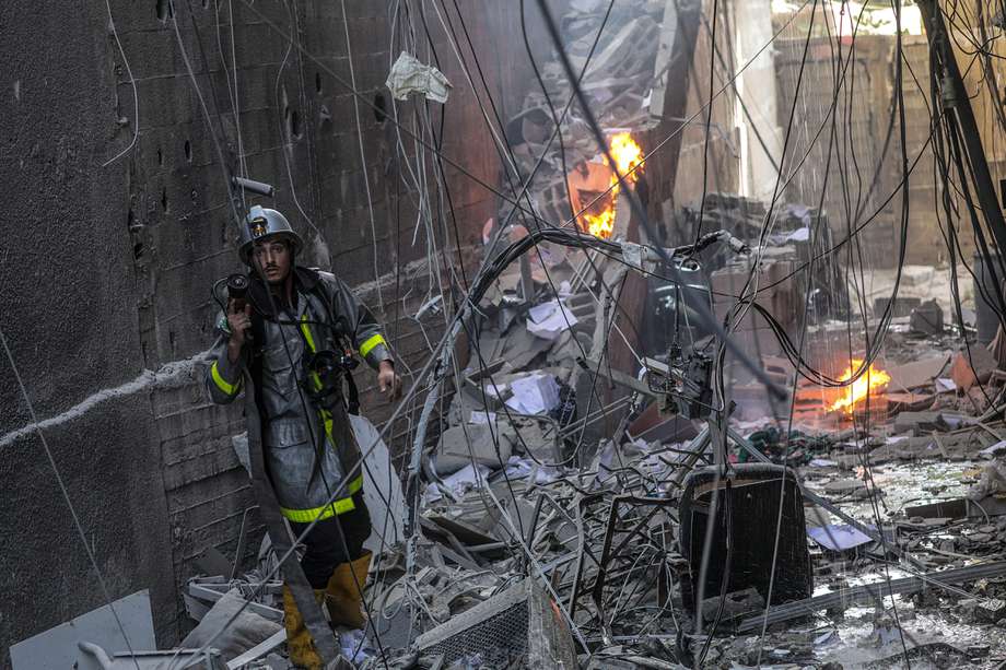 Un bombero palestino trabaja en el lugar de un edificio destruido tras los ataques aéreos israelíes en Gaza.