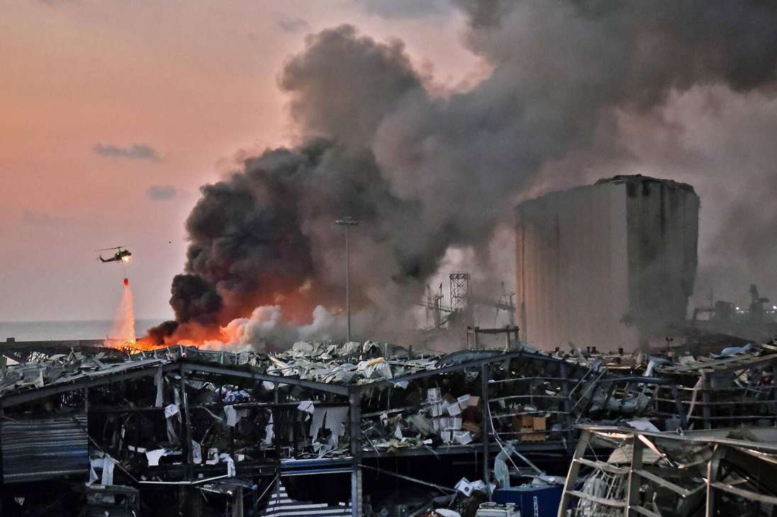 Un helicóptero apaga un incendio en el lugar de una inmensa explosión en el puerto de Beirut, la capital del Líbano, provocada por materiales químicos almacenados desde hace tiempo. 4 de agosto de 2020.