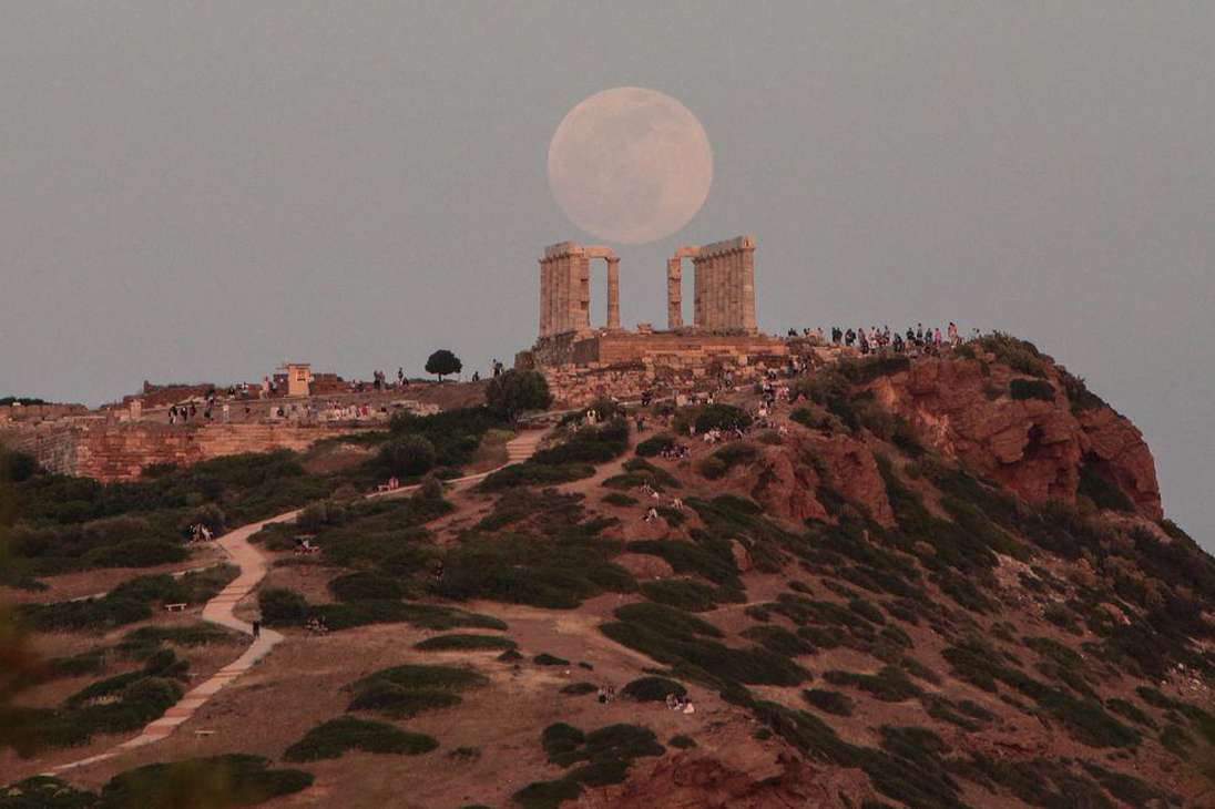 La luna llena se eleva sobre el templo de Poseidón, un día antes del eclipse lunar, en el cabo Sounio, a 65 km al sur de Atenas, Grecia.