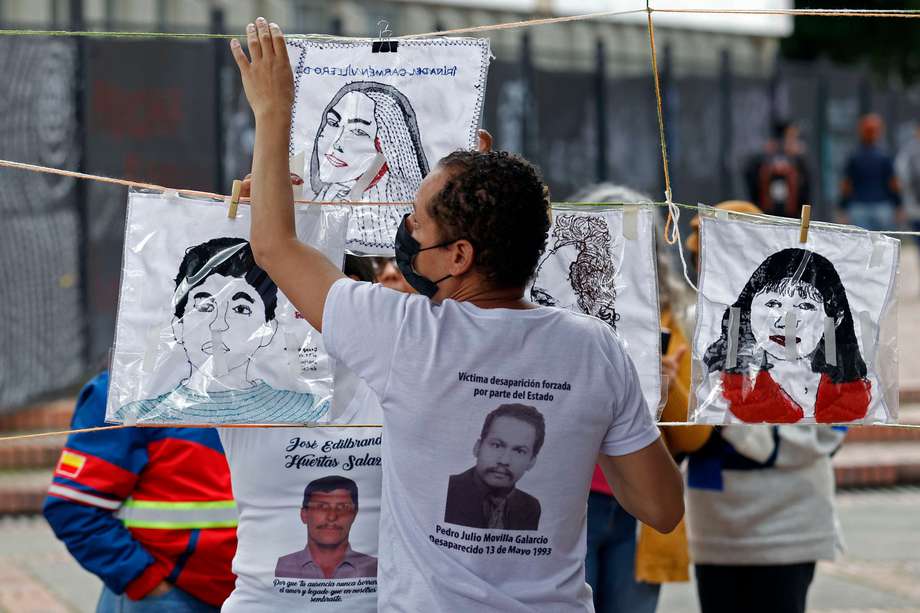 Familiares cuelgan cuadros tejidos de personas desaparecidos hoy, durante la conmemoración del Día Internacional de las Víctimas de Desapariciones Forzadas, en la Universidad Nacional. 