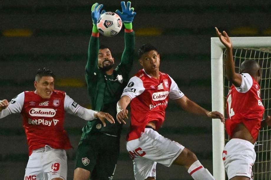 Los jugadores de Independiente Santa Fe disputan un balón con el portero Marcos Felipe de Fluminense.