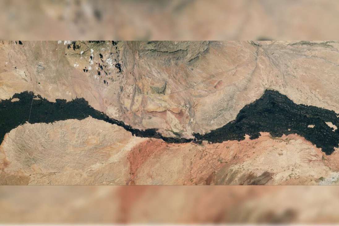 Un astronauta a bordo de la ISS tomó una impresionante foto de una antigua colada de lava que se extiende por el desierto de Nuevo México. 
El flujo de lava, conocido como el Carrizozo Malpaís, cubre unos 337 km² y tiene unos 80 km de largo. Desde arriba, el río helado de roca volcánica parece una cicatriz oscura tallada en el desierto circundante.