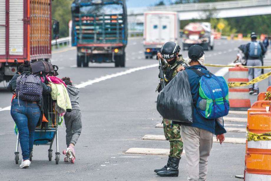 Migrantes venezolanos caminan con sus pertenencias al costado de la carretera que sale de Bogotá. / Getty Images