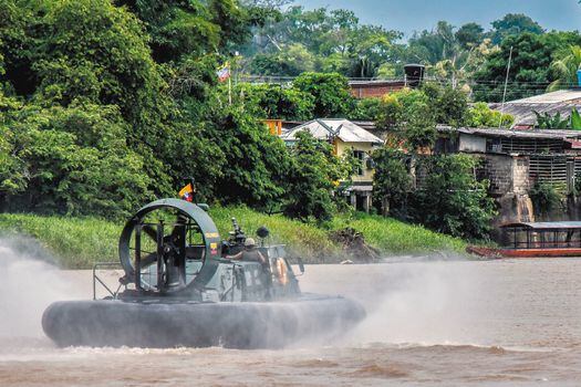 Colombian soldiers cruise the Arauca river in Arauquita municipality, Arauca department, Colombia, on March 26, 2021. Almost 4,000 people -mostly Venezuelans- have arrived in the bordering municipality of Arauquita, northeast Coolombia, between Sunday and Thursday displaced by combats between Venezuelan military men and a Colombian armed group. / AFP / Daniel MARTINEZ

