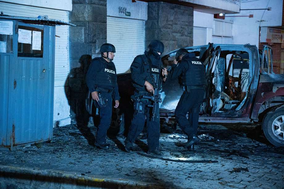 Policías investigan los restos de un carro bomba que explotó este miércoles en los exteriores del edificio del Servicio Nacional de Atención Integral a Personas Privadas de Libertad (SNAI), en Quito (Ecuador). 