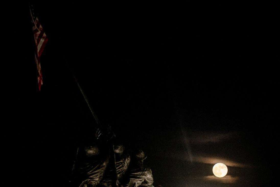 9.	La "luna de fresa" llena se ve por delante del Memorial de Guerra del Cuerpo de Marines de Estados Unidos en Arlington, Virginia, el 14 de junio de 2022.