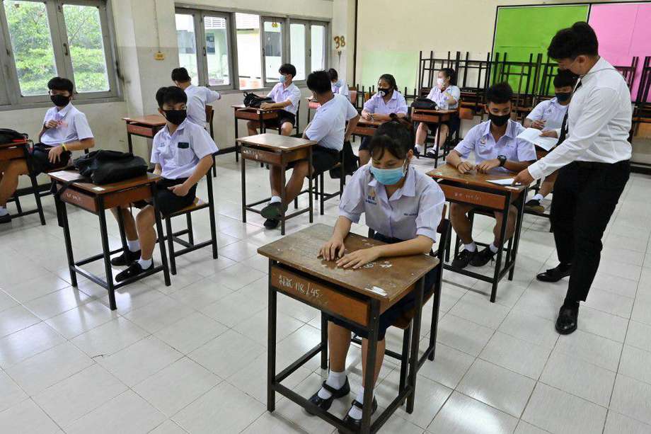 Un profesor atiende interactúa con sus estudiantes en una clase en Tailandia, dónde el gobierno recomendó que las aulas no tuvieran más de 25 personas juntas.