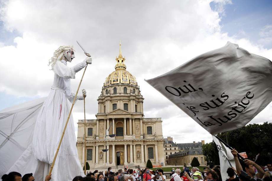 Empleados del sector sanitario ondean banderas en las que puede leerse 'Sí, yo soy la Justicia', durante una manifestación en París (Francia), este martes.