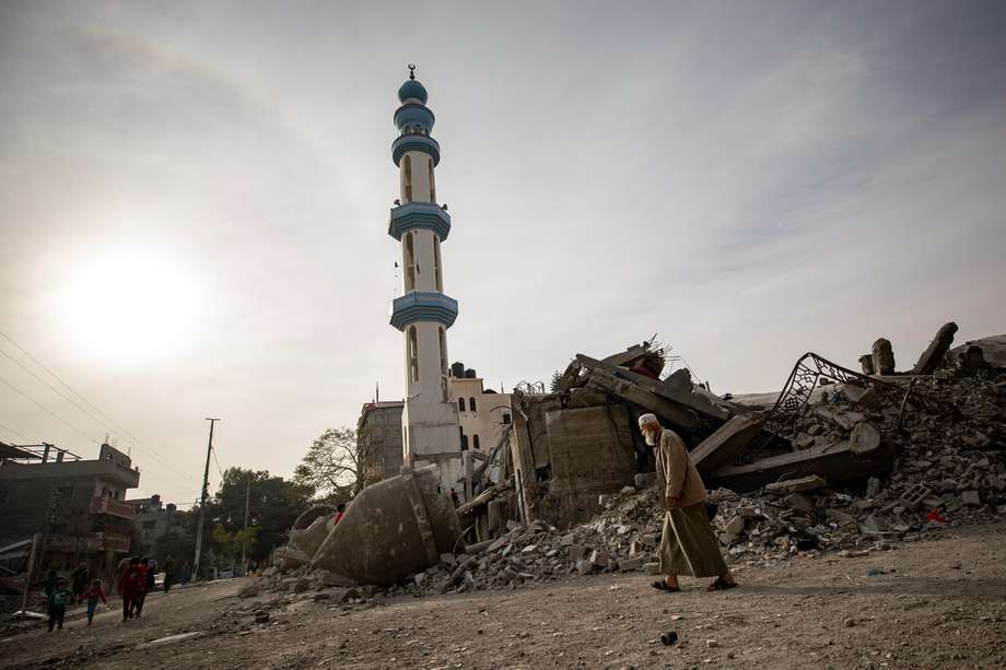 Palestinos pasan junto a las ruinas de la mezquita de Al Farouq tras ser destruida por un ataque aéreo israelí hace unos días en el campo de refugiados de Rafah, sur de la Franja de Gaza, 23 de febrero de 2024.