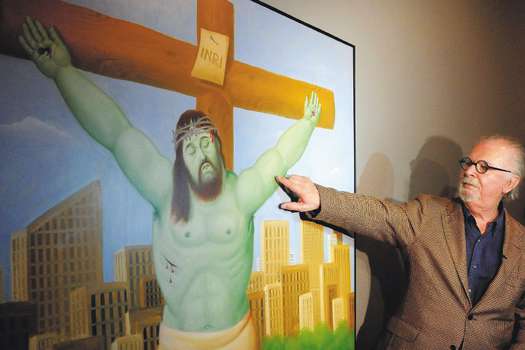 El artista colombiano Fernando Botero muestra detalles de uno de sus cuadros que hace parte de la exposición "Vía Crucis".