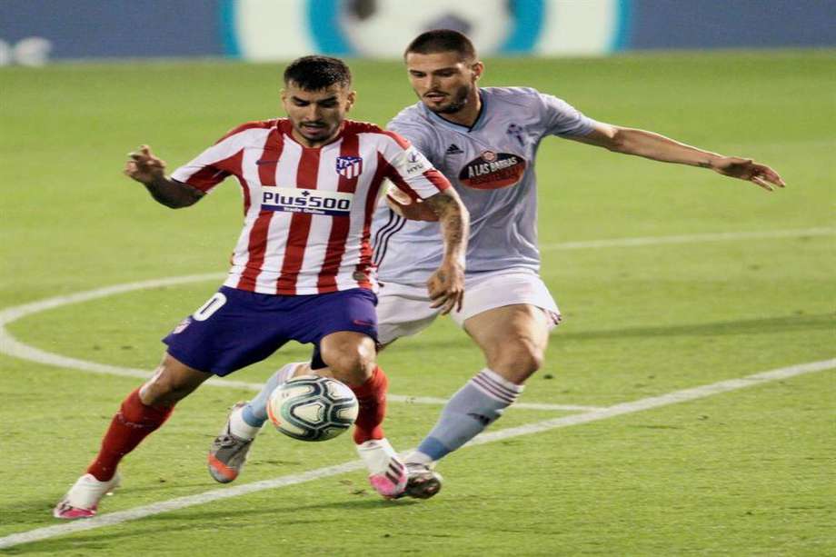 Ángel Correa, delantero del Atlético de Madrid, protegiendo el balón ante el ataque del centrocampista turco del Celta de Vigo, Okay Yokuslu.
