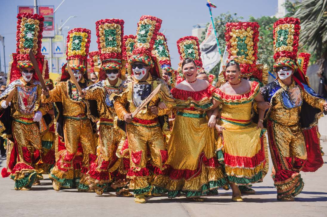 Hombres y mujeres danzan con vestidos folclóricos por las calles de Barranquilla durante el Carnaval realizado en febrero del 2024.