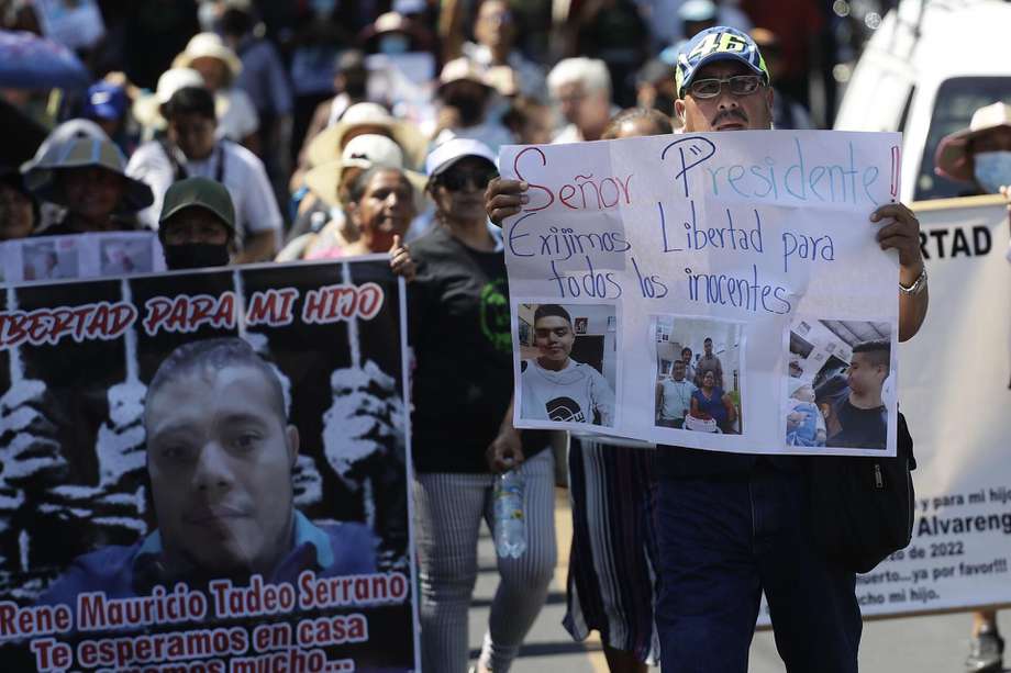 Una mujer muestra un cartel con fotografías de una joven y el pedido de su libertad, durante una marcha de familiares de detenidos en el contexto del régimen de excepción en El Salvador.
