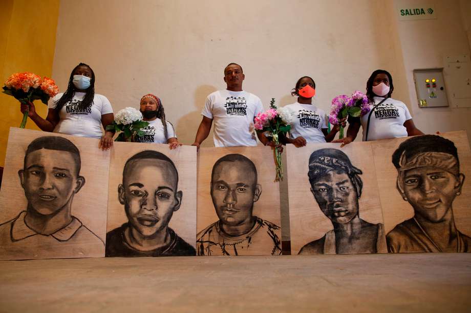 Familiares de las víctimas de la masacre de Llano Verde, sostienen hoy retratos suyos durante un acto conmemorativo.