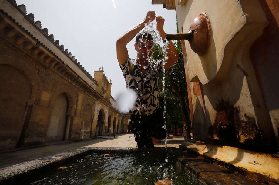 Un joven se refresca en una fuente de del Patio de los Naranjos de la Mezquita-Catedral de Córdoba. La primera ola de calor que afecta a España este verano llega a su fin este miércoles con valores aún muy altos, hasta 42 °C. 
